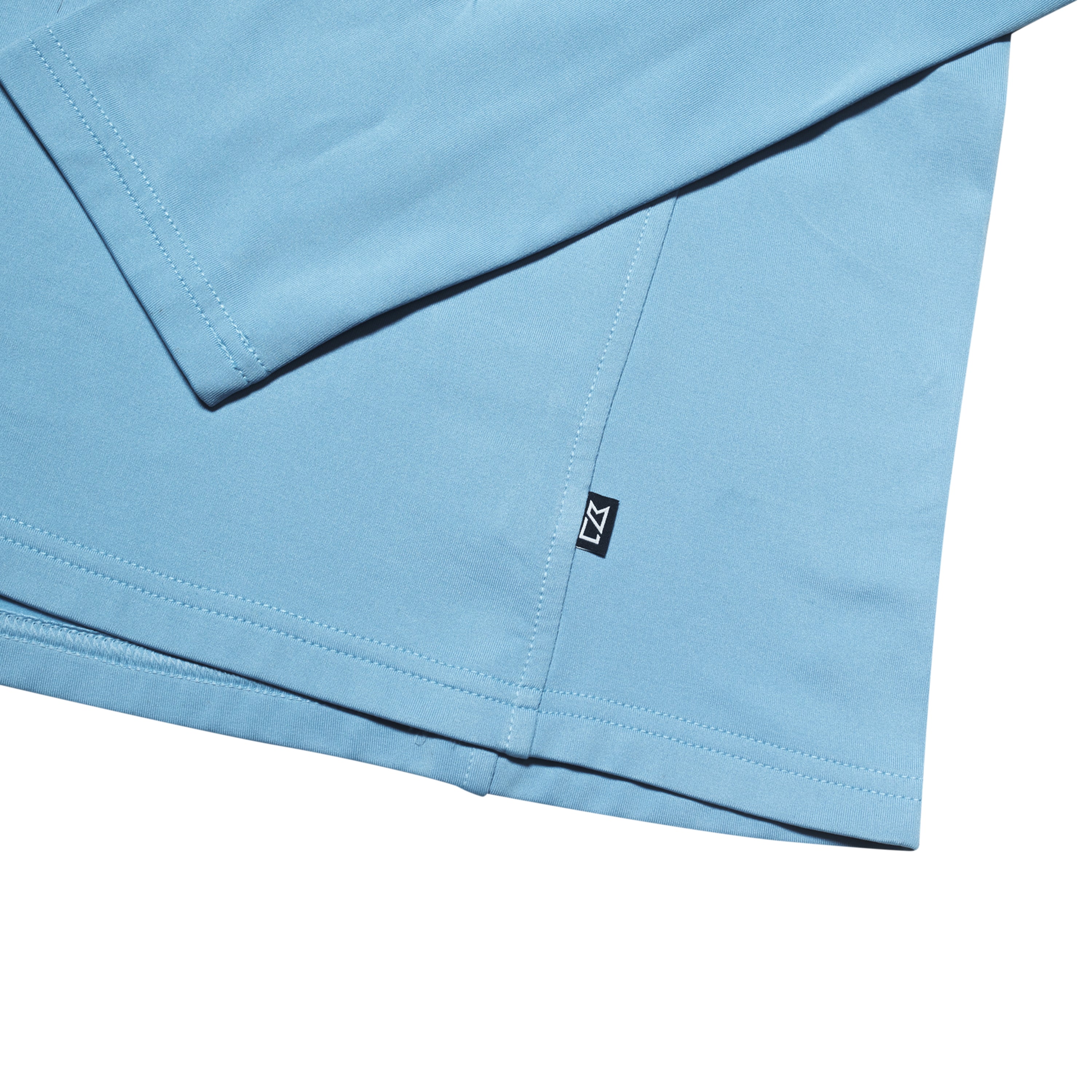 Light blue long-sleeve shirt with a tag at the hem.