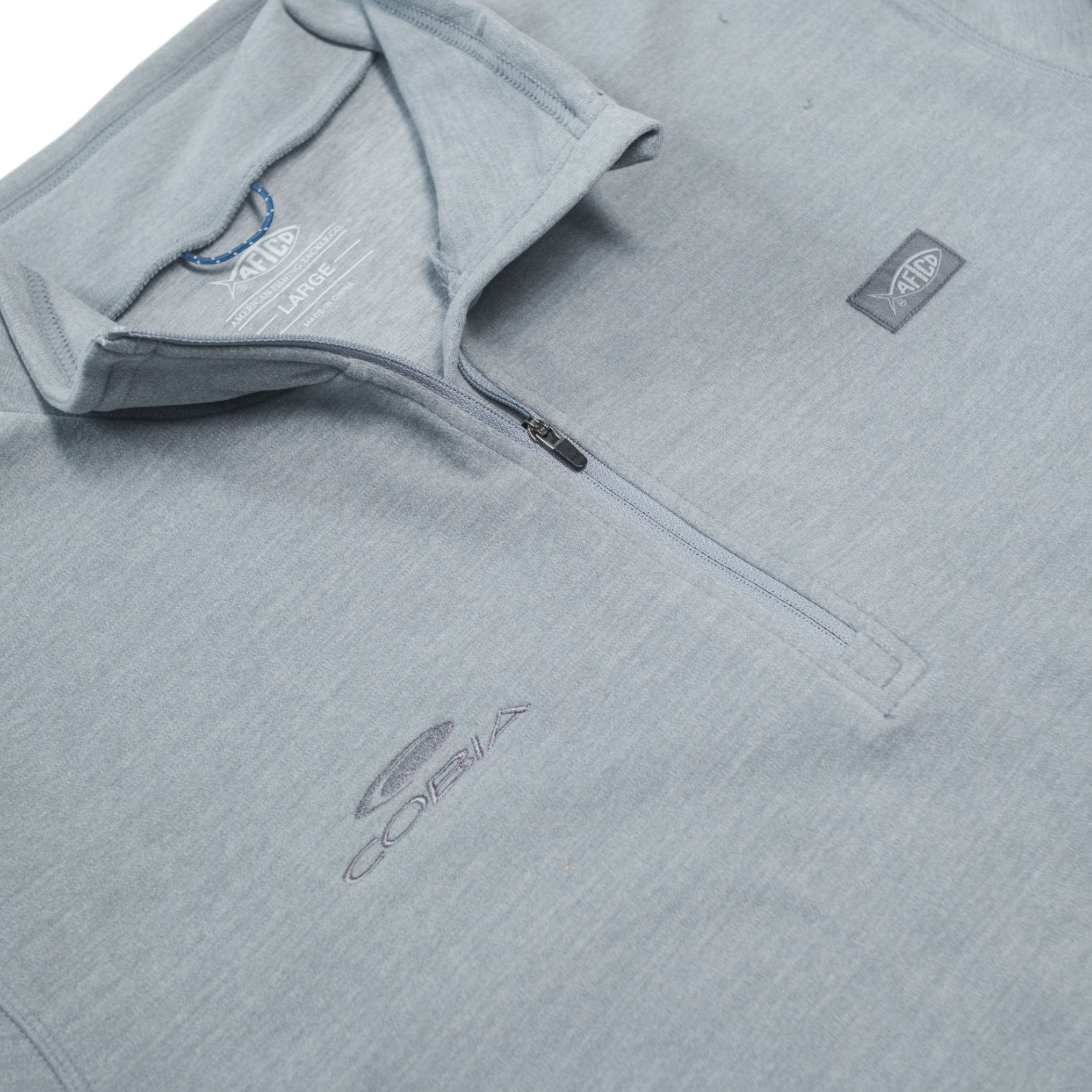 Light gray quarter-zip pullover with the cobia logo and ATFCO logo details.