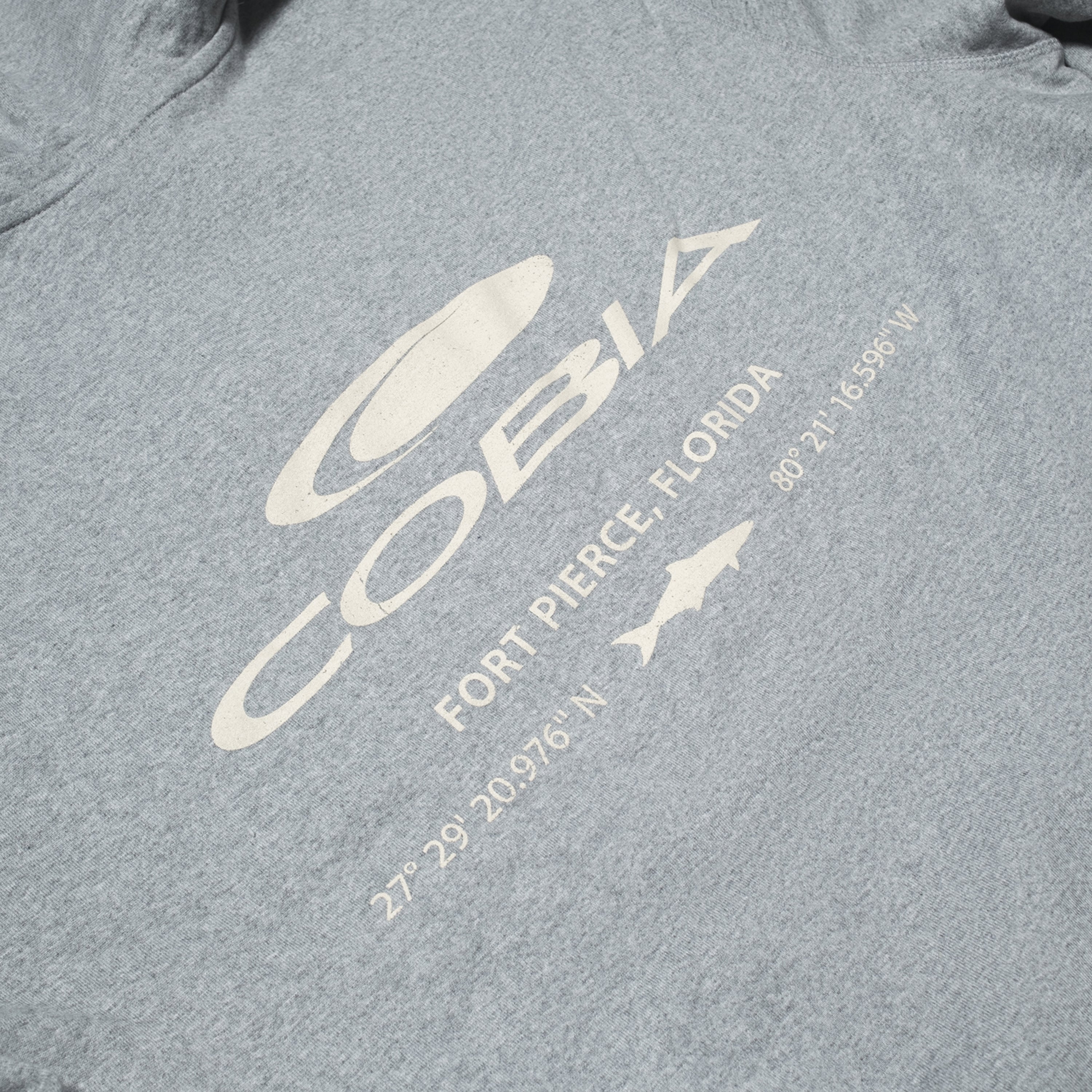 Close up of the back graphic of a hoodie, featuring 'Cobia' and location details for Fort Pierce, Florida.