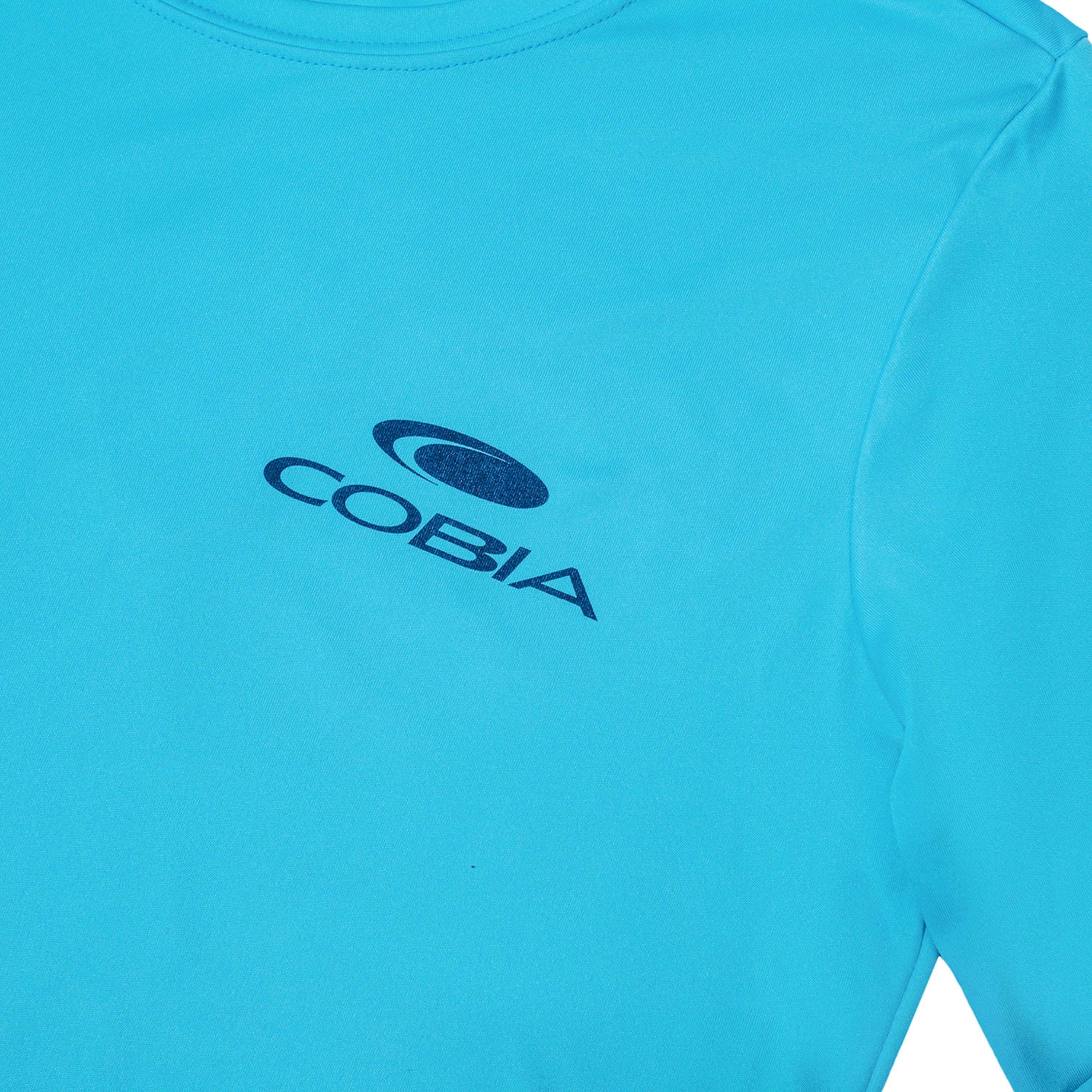 Close-up of a teal shirt featuring the COBIA logo in navy on the chest.