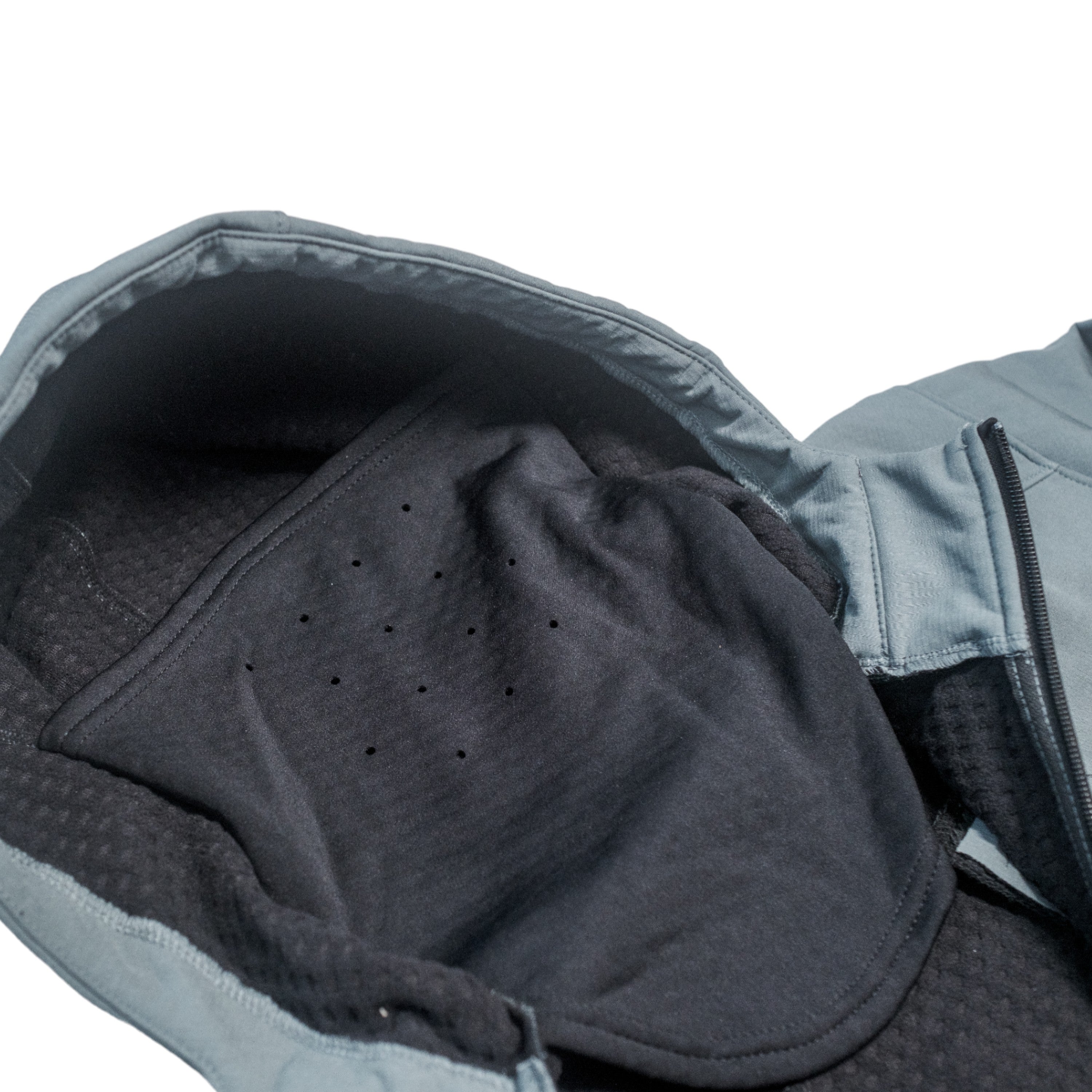 Interior view of a gray jacket showing a dark inner lining and neck gaiter in the hood.