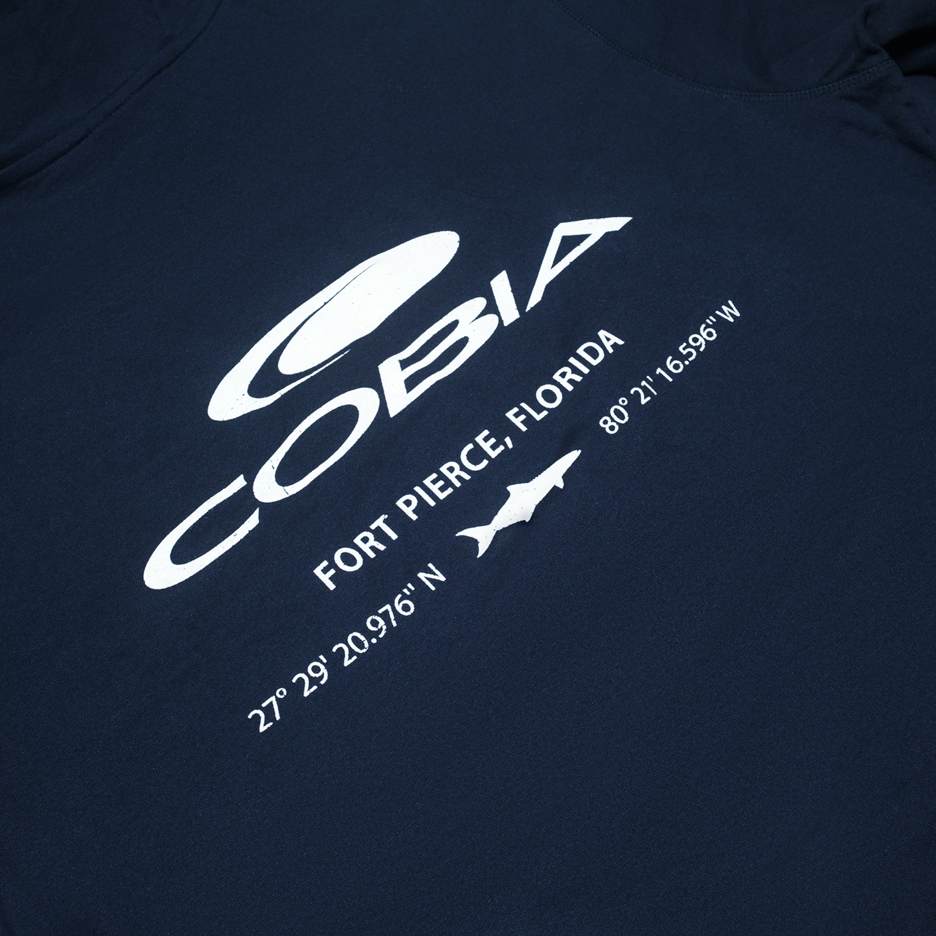 Close up of a navy shirt with the word 'COBIA' and coordinates for Fort Pierce, Florida.