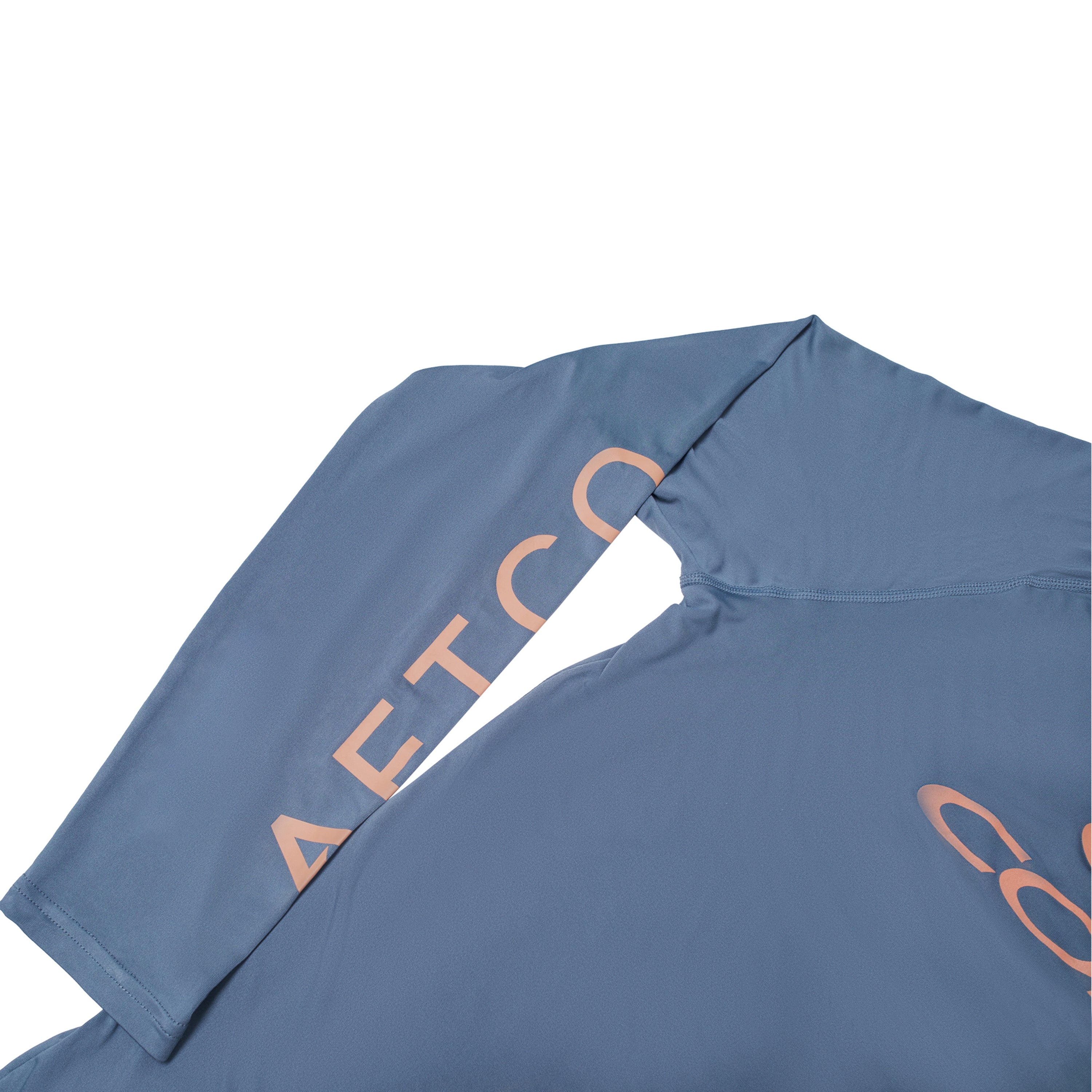 A close-up of a long-sleeve blue shirt with pink AFTCO branding on the sleeve.