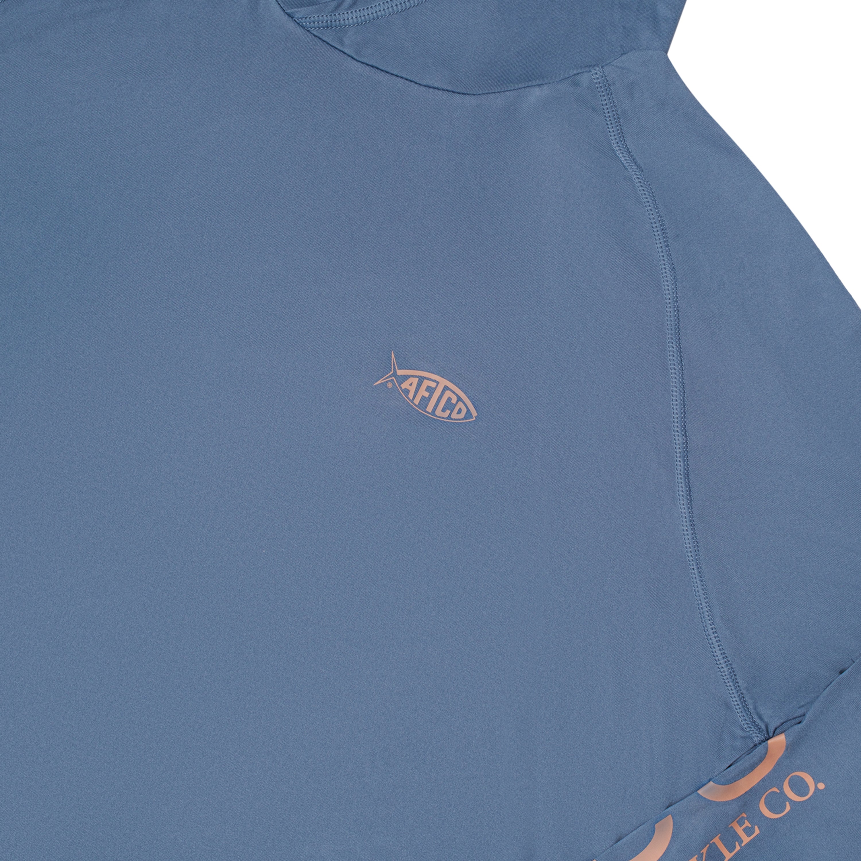 Light blue grey shirt with a small pink aftco logo on the chest and brand name on the sleeve.
