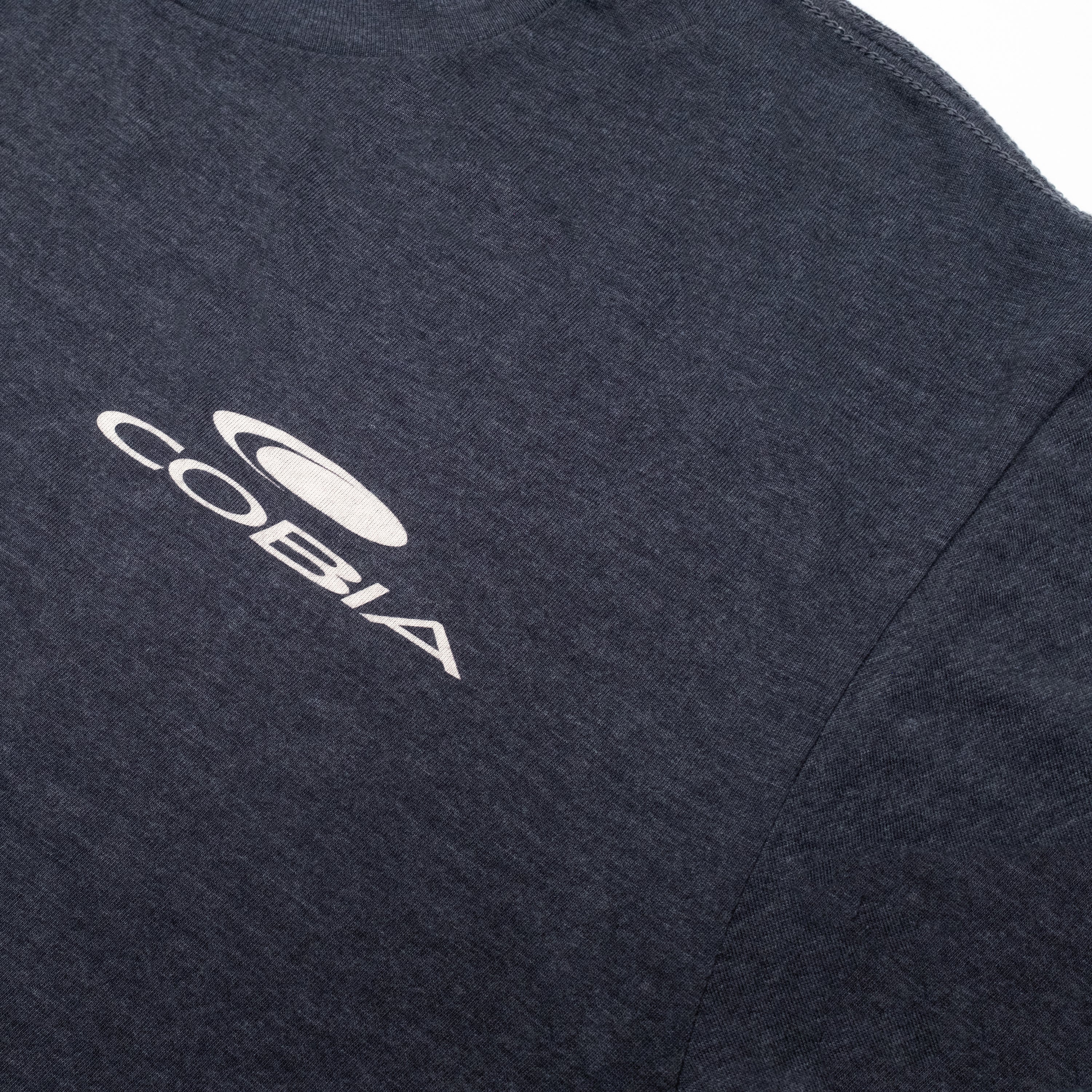 Close-up of a dark grey shirt with the word 'COBIA' printed in white on the chest.
