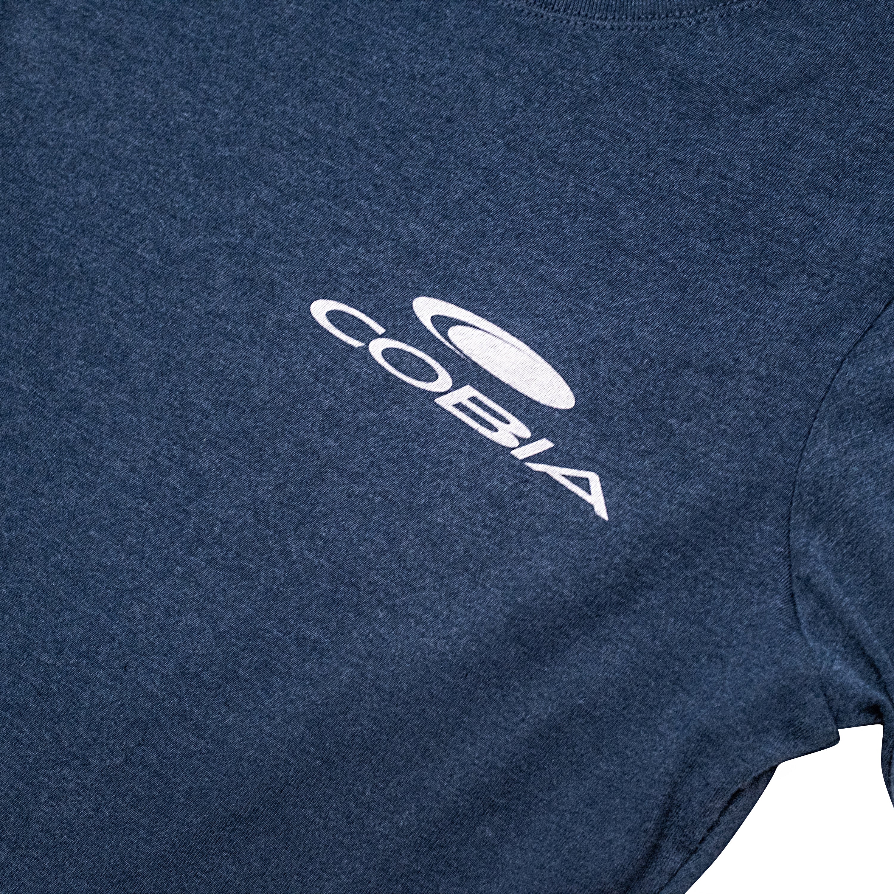 Close-up of a navy blue T-shirt featuring the Cobia logo in white on the chest.