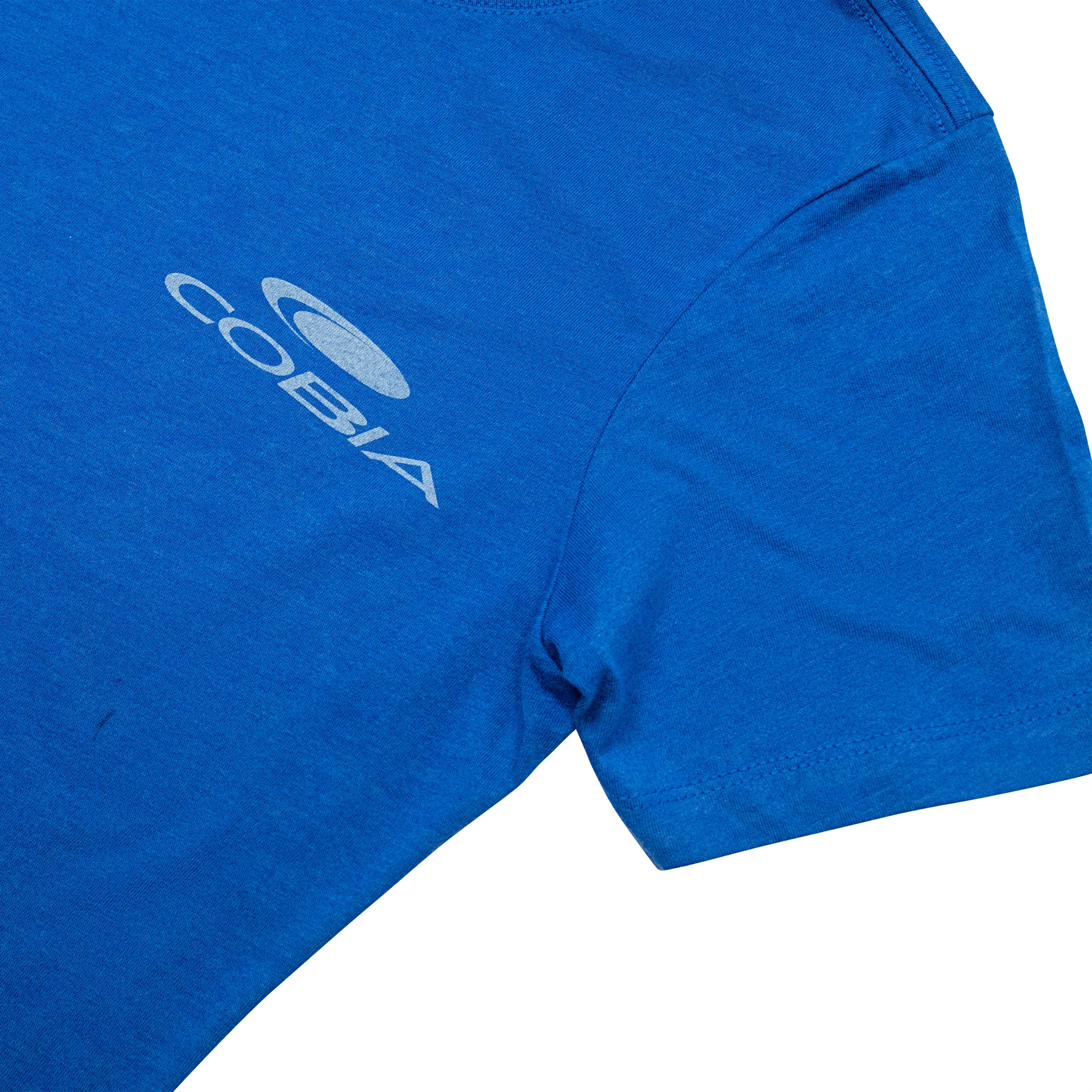 Close-up of a blue T-shirt with a white cobia logo on the left chest.