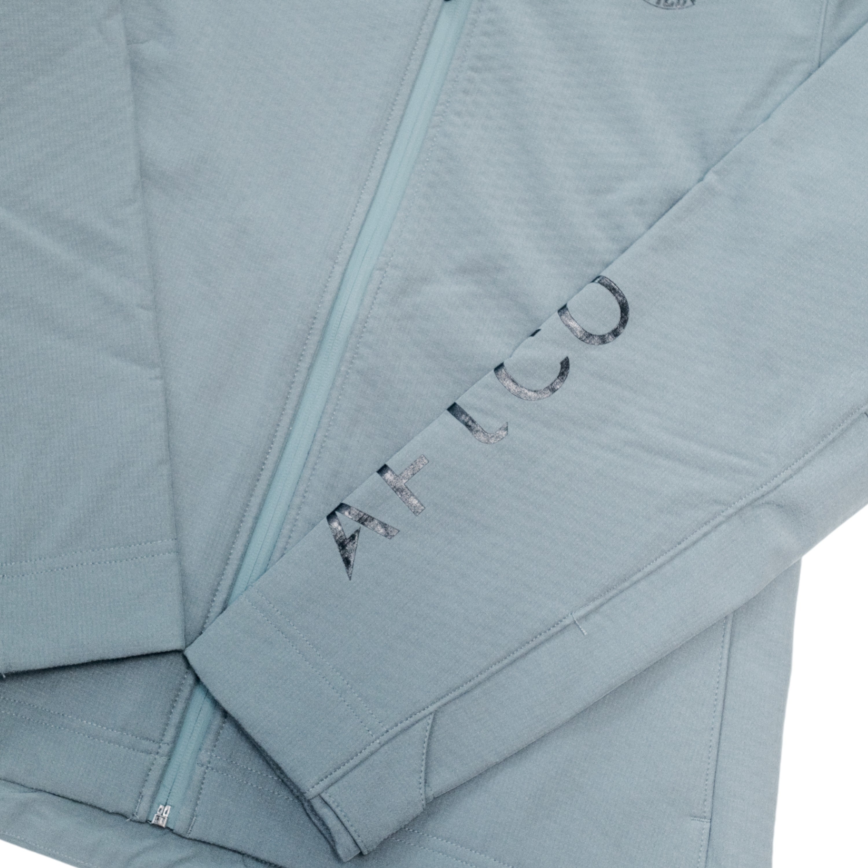 Close-up of a light grey jacket with 'AFTCO' text on the sleeve in black.