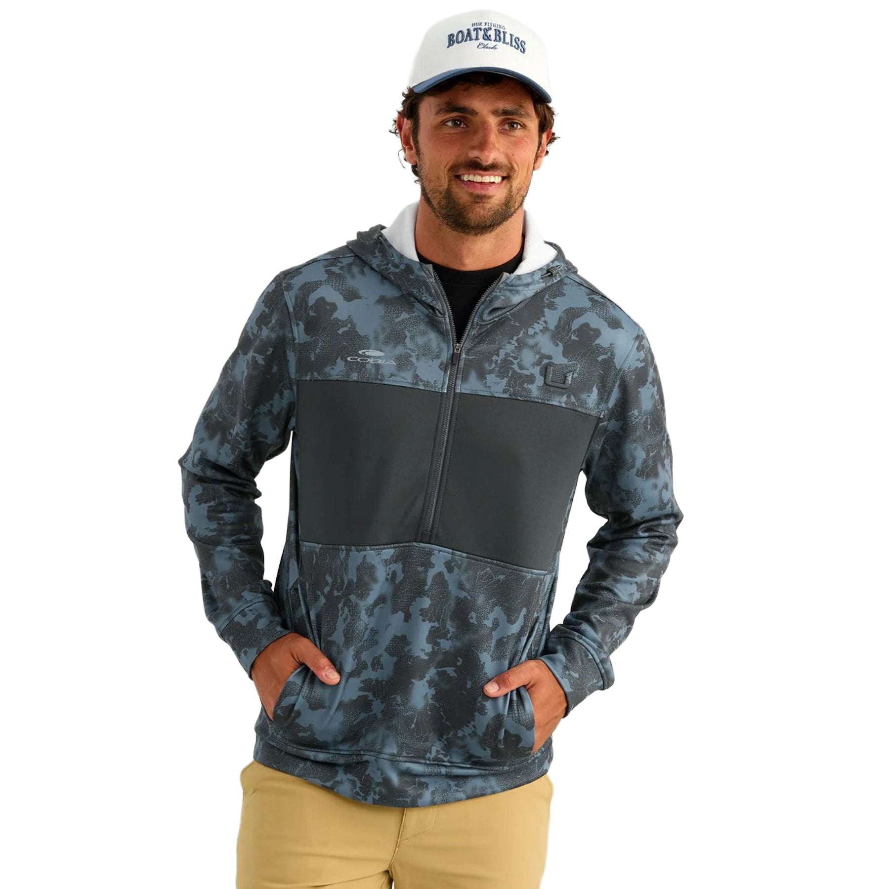 A man wearing a blue hooded half-zip jacket with a digital camo pattern and a cobia logo on the right chest.