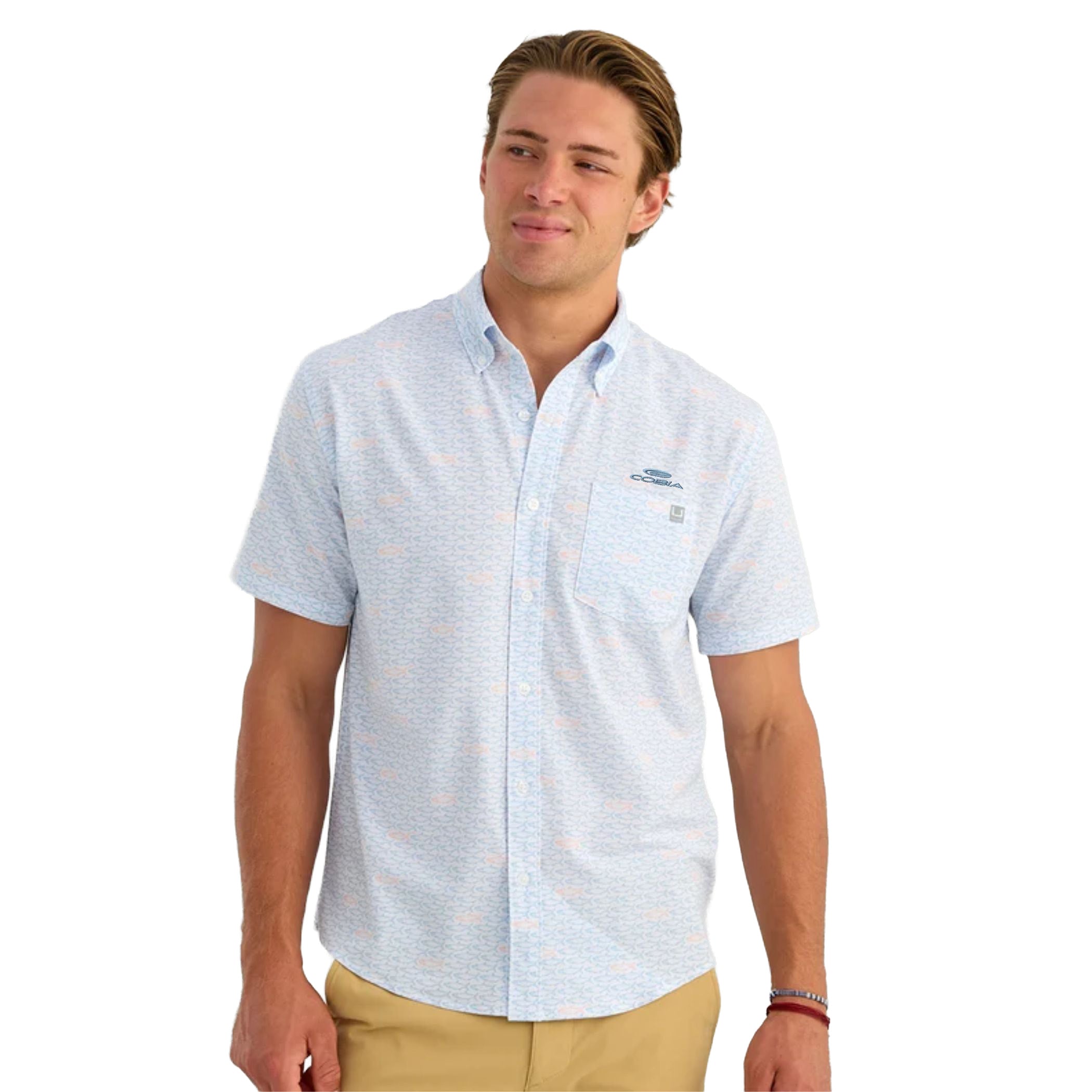 Man wearing a white short-sleeve button-up with a light blue fish pattern across it and an embroidered cobia logo on the left chest.