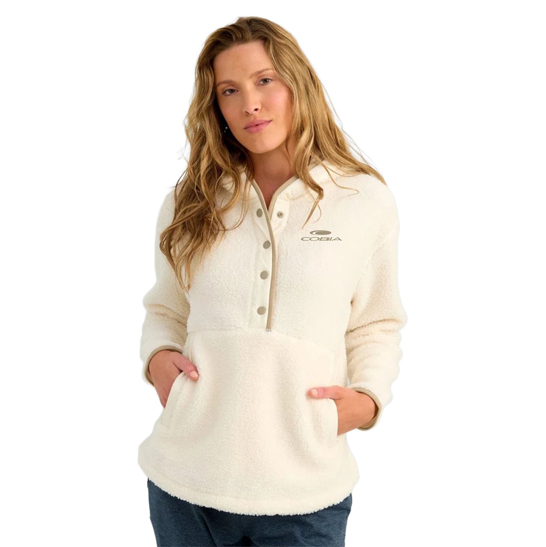 A woman wearing a cream-colored fleece pullover with a buttoned collar and front pockets, featuring a small embroidered Cobia logo on the left chest, set against a plain white background.