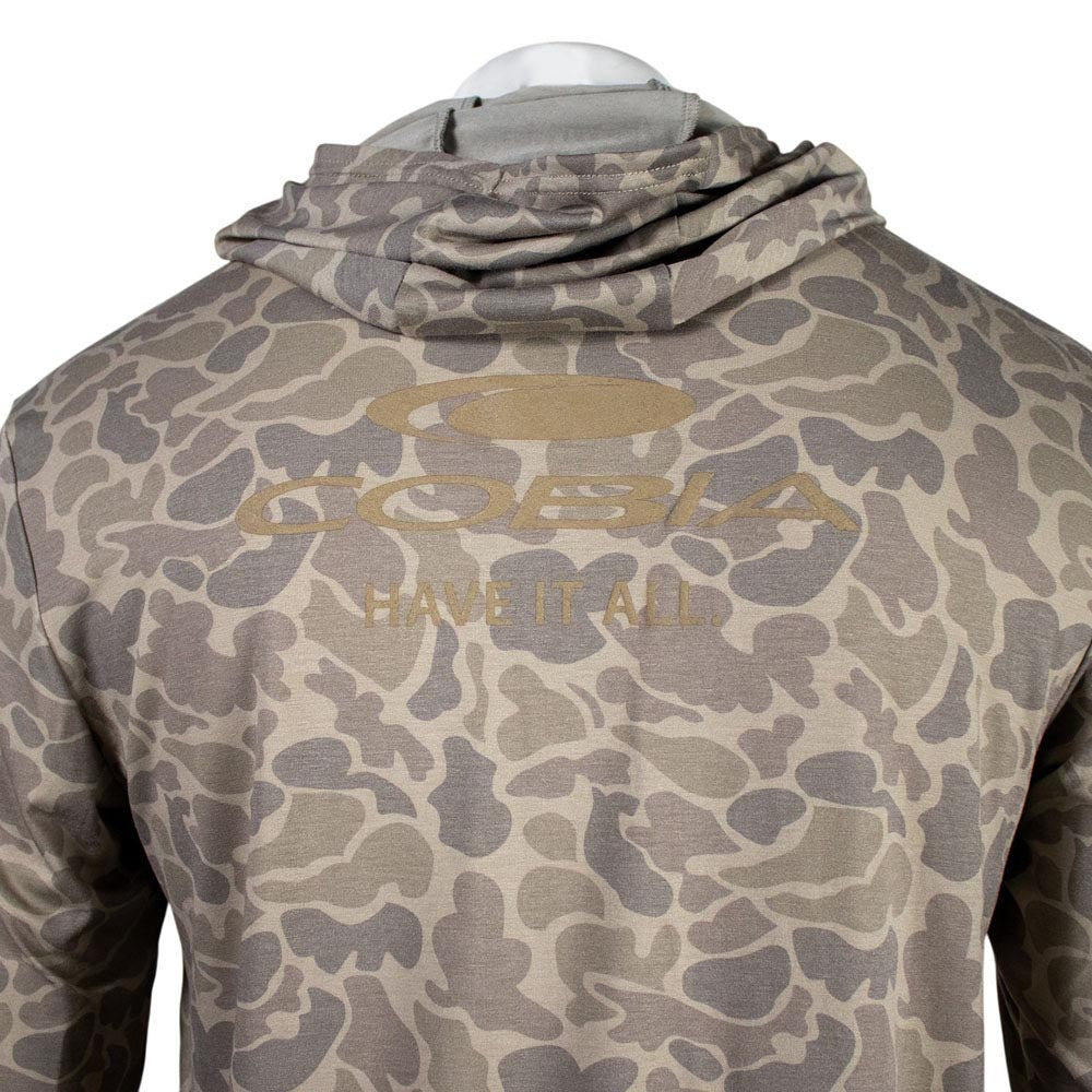 Close up of a tan camouflage hoodie with a brown cobia logo on the shoulder blades.