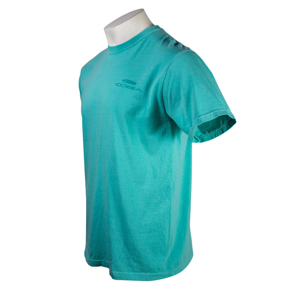 Side of a teal t-shirt with a dark teal Cobia logo on the left chest.