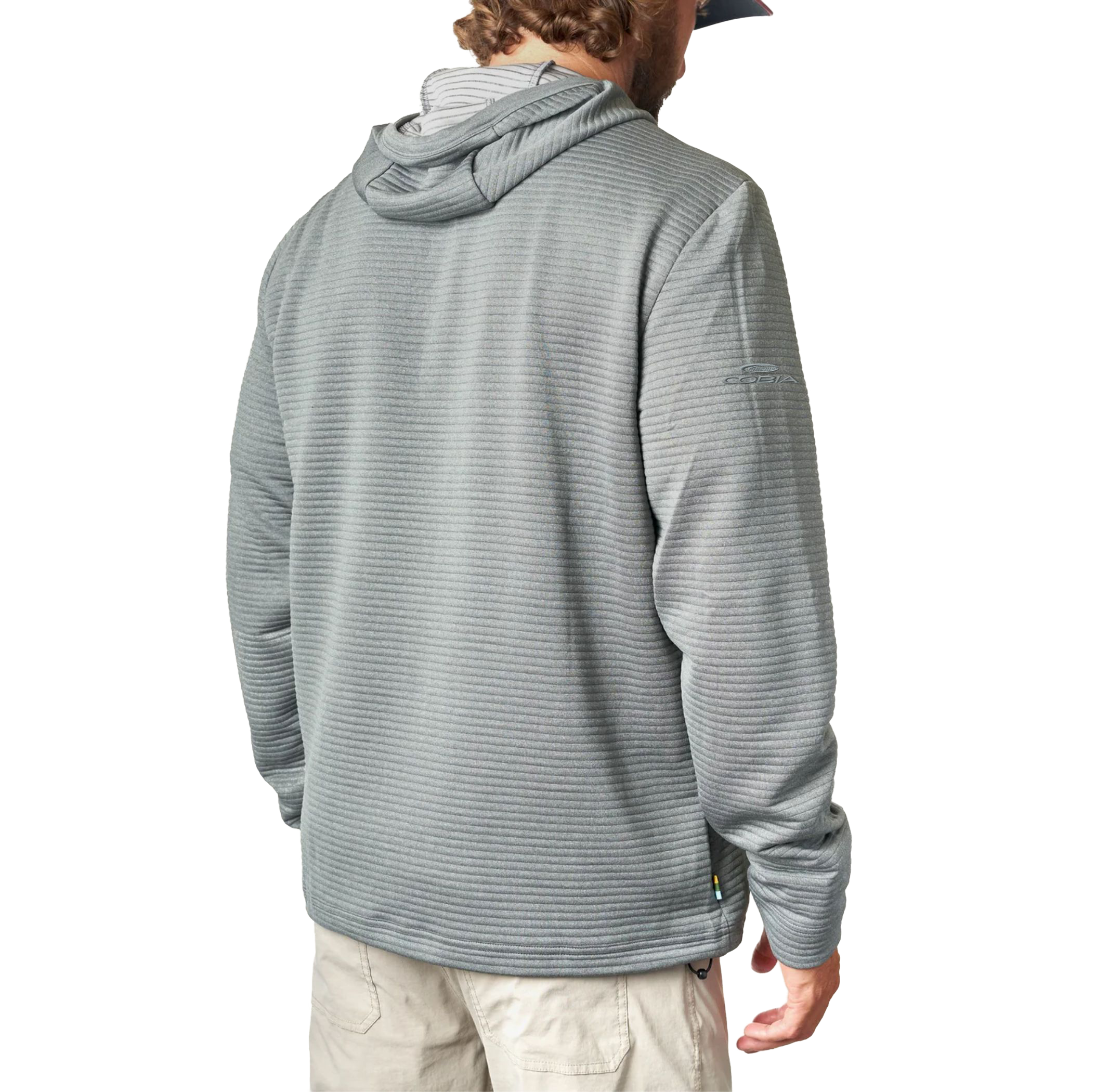 Man wearing a ribbed grey hooded long sleeve with an embroidered brand logo on the sleeve.