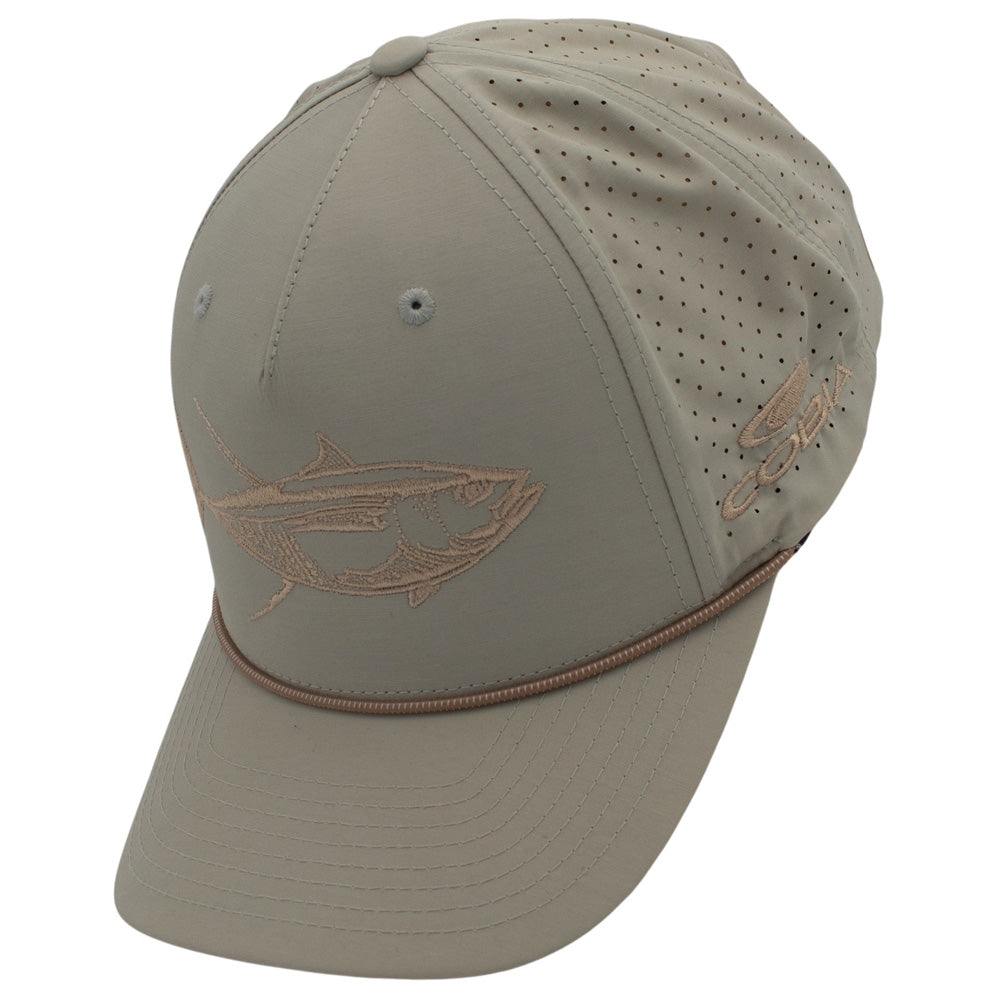 Side of a light beige cap with a fish design on the front and the cobia logo on the side.